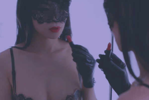 Colette Pervette dominatrix putting on lipstick in mirror BDSM