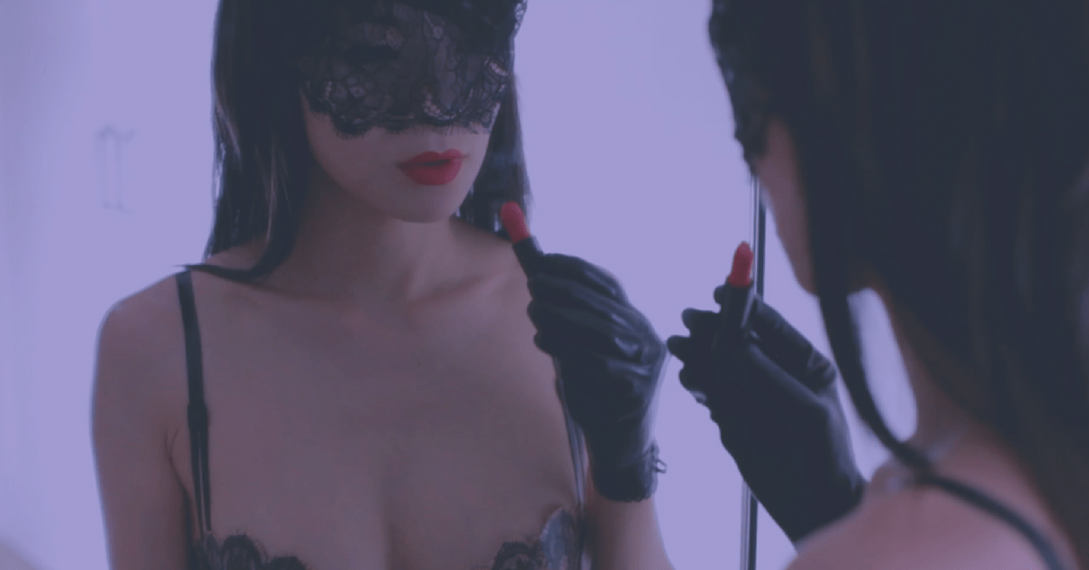 Colette Pervette dominatrix putting on lipstick in mirror BDSM