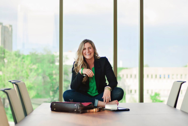 Kelsey Ramden sitting on a conference table