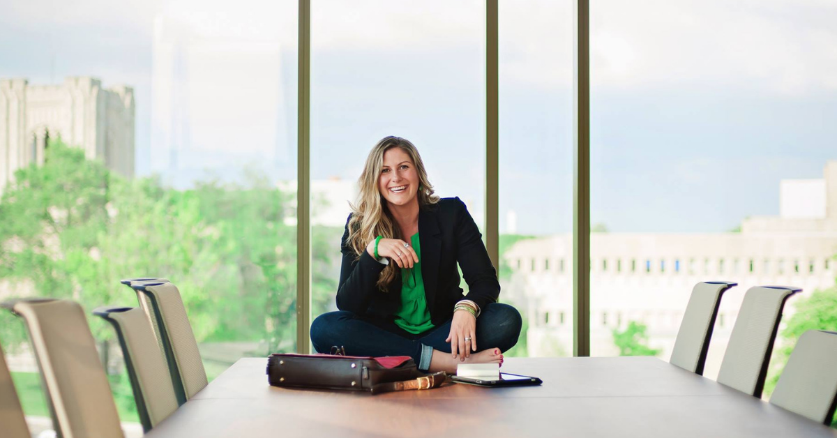 Kelsey Ramden sitting on a conference table